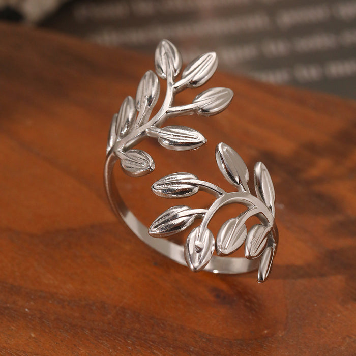 Close-up of silver olive leaf ring on wooden surface