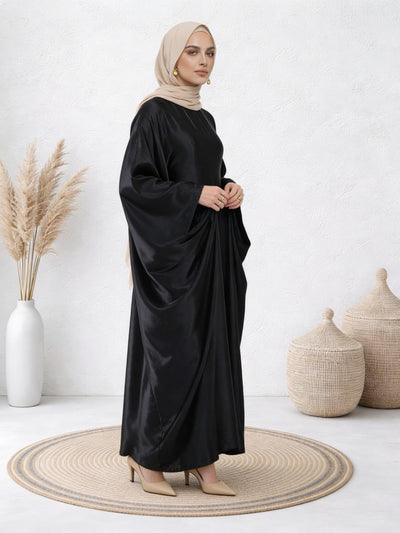 Woman wearing Black abaya with smooth satin finish and graceful, full-length drape
