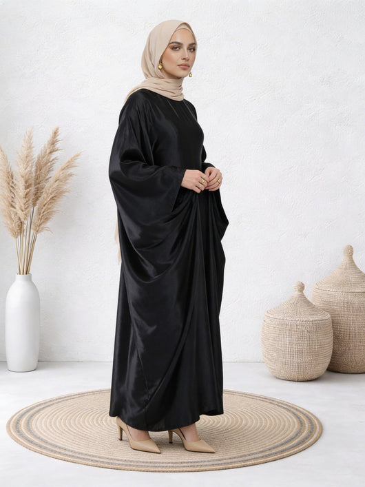 Woman wearing Black abaya with smooth satin finish and graceful, full-length drape