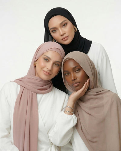 Three women wearing the new Nuramira instant chiffon hijabs in black, blush, and praline with different drape styles in white studio