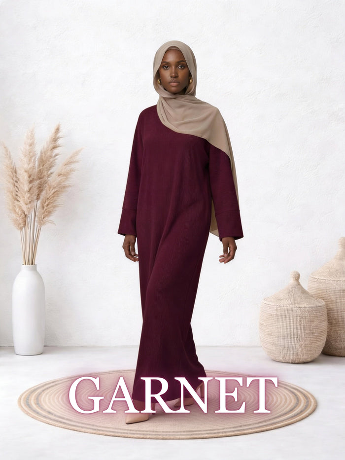 Front view of a model wearing the Amanah Abaya in Garnet, featuring a deep burgundy color and elegant flow.