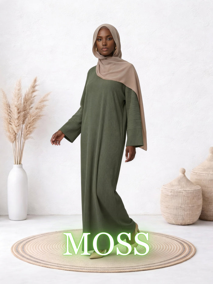 Model wearing the Amanah Abaya in Moss, featuring a relaxed olive-green silhouette and matching modest styling.