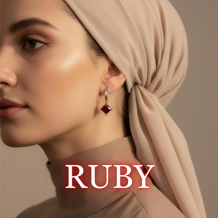 Woman wearing Amara drop earrings in ruby with warm beige tones