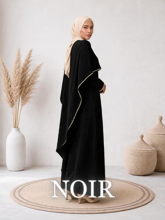 Side-view of a woman wearing the Amara™ Abaya in Noir, highlighting the elegant cape detail.