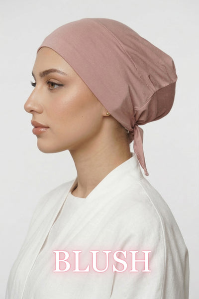 Side profile of model wearing blush Amina undercap with mesh back and adjustable tie-back