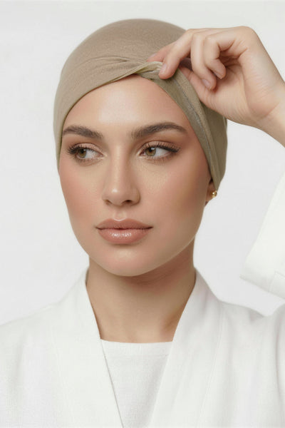 Model lifting praline beige Amina velvet hold undercap to reveal velvet grip front panel in white studio 