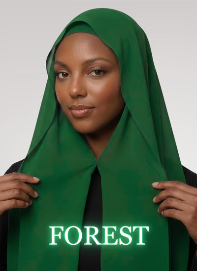 Woman wearing forest green NurAmira instant chiffon hijab with front panels held by magnets and smooth drape in white studio