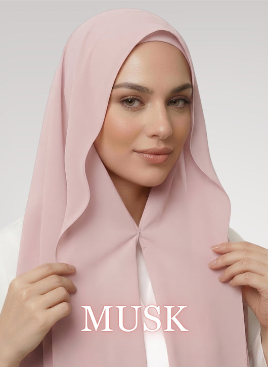 Woman wearing musk pink NurAmira instant chiffon hijab with front panels held by magnets and smooth drape in white studio