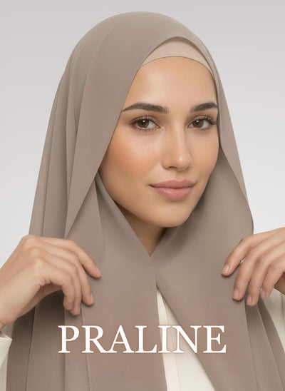 Woman wearing praline beige NurAmira instant chiffon hijab with front panels held by magnets and smooth drape in white studio
