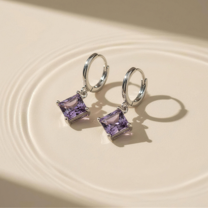 Amara drop earrings in amethyst on neutral surface with soft light reflections