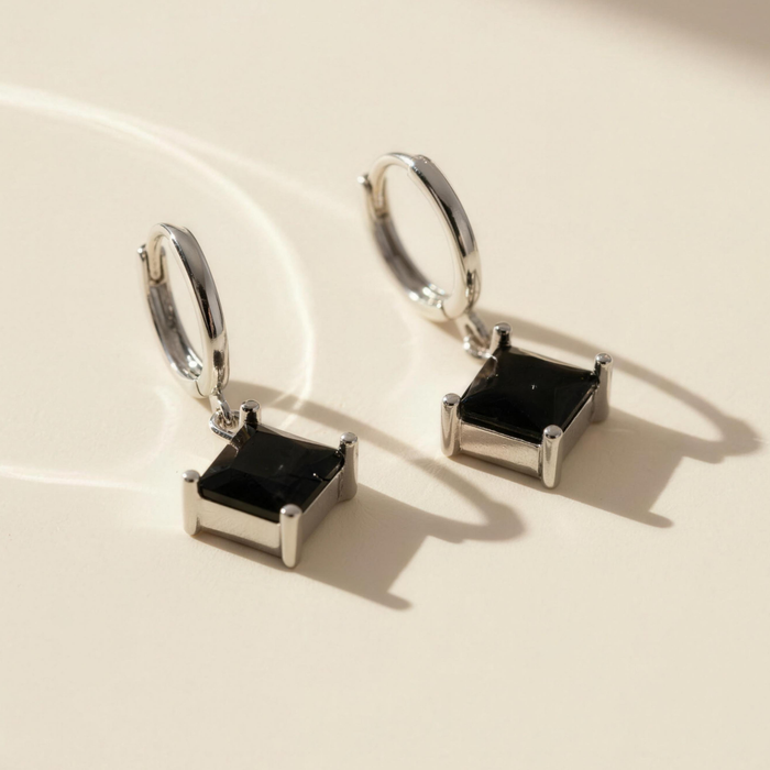 Amara drop earrings in onyx on minimal background with reflective shadows