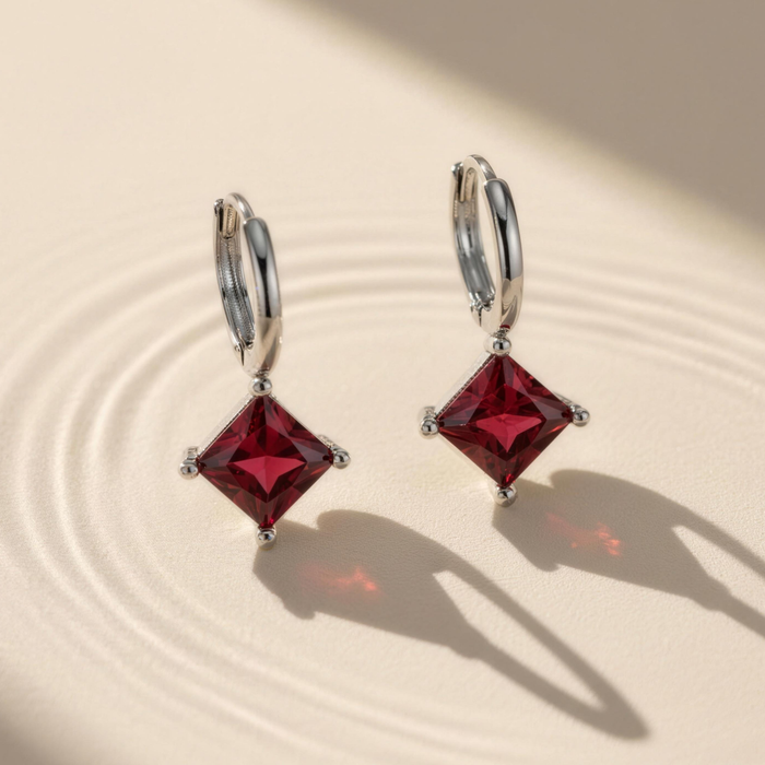 Amara drop earrings in ruby on minimal background with soft shadow detail