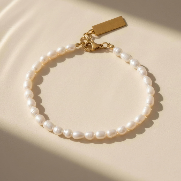 Liyana pearl bracelet with gold clasp on minimal background with soft lighting