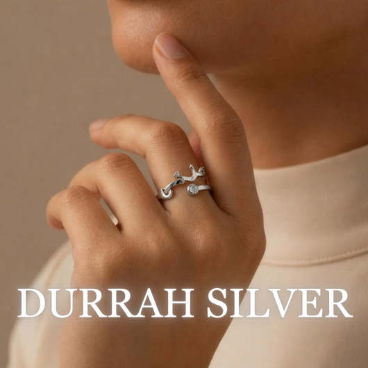 Woman wearing Durrah silver ring with stone detail in warm lighting