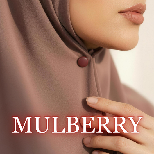 Close-up of a model wearing a mauve hijab secured under the chin with a matte deep red "Mulberry" magnet, with her hand touching the fabric and the text "MULBERRY" overlaid at the bottom.