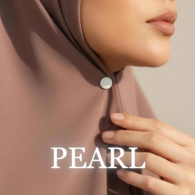 Close-up of a model wearing a taupe brown hijab secured under the chin with a matte white "Pearl" magnet, with her hand touching the hijab fold and the text "PEARL" overlaid at the bottom.
