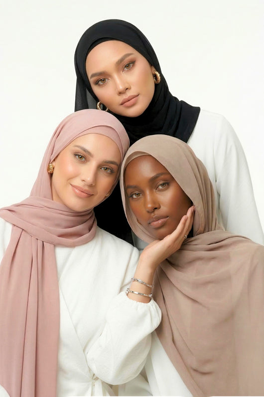 Three women wearing the new Nuramira instant chiffon hijabs in black, blush, and praline with different drape styles in white studio