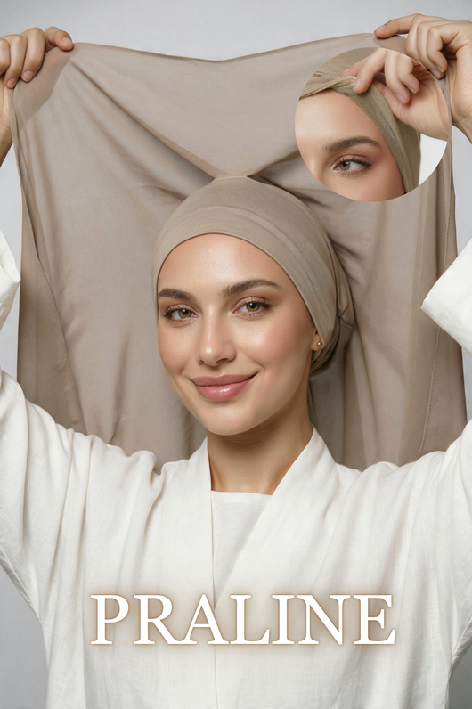 A woman wearing a beige headscarf or hijab-style cap, holding up a larger matching fabric panel behind her head. She is dressed in a white robe against a light gray studio background, with the brand name PRALINE displayed at the bottom and a circular inset showing a close-up of the fabric texture.