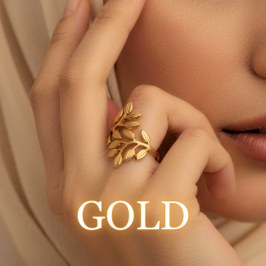 Woman wearing Noora olive leaf ring in gold with soft lighting