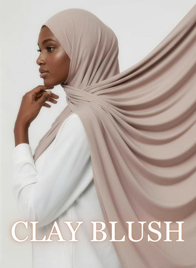 Woman wearing clay blush NurAmaya™ modal hijab with soft drape in white studio