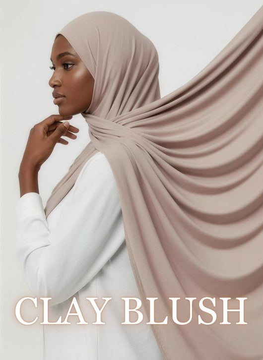 Woman wearing clay blush NurAmaya™ modal hijab with soft drape in white studio