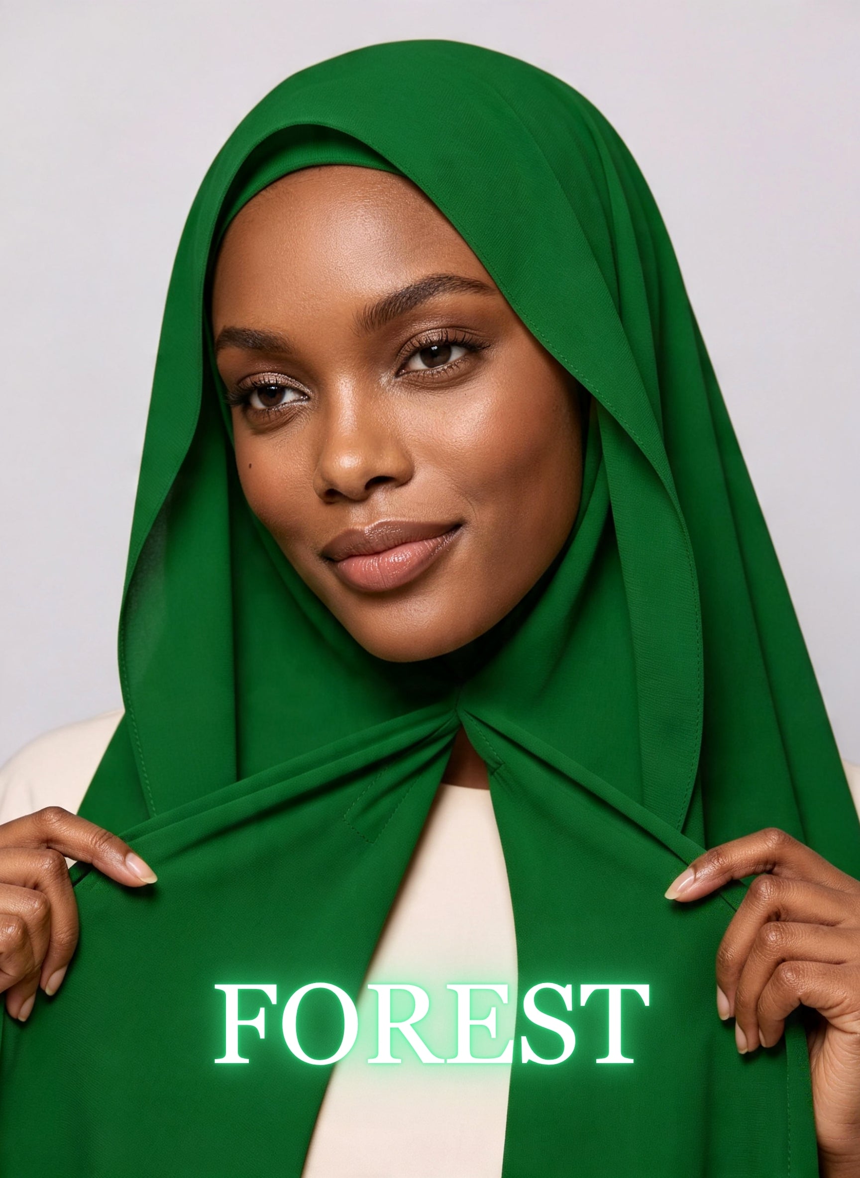 Woman wearing forest green NurAmira instant chiffon hijab with front panels held by magnets and smooth drape in white studio