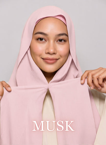 Woman wearing musk pink NurAmira instant chiffon hijab with front panels held by magnets and smooth drape in white studio
