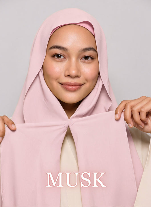 Woman wearing musk pink NurAmira instant chiffon hijab with front panels held by magnets and smooth drape in white studio