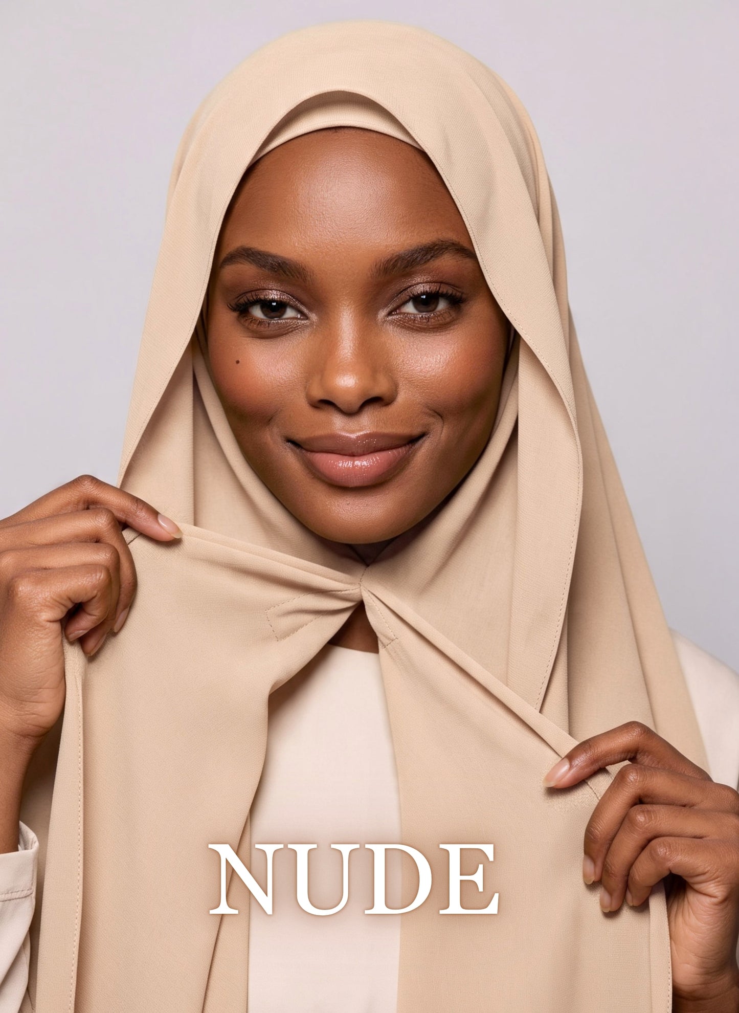 Woman wearing nude beige NurAmira instant chiffon hijab with front panels held by magnets and smooth drape in white studio