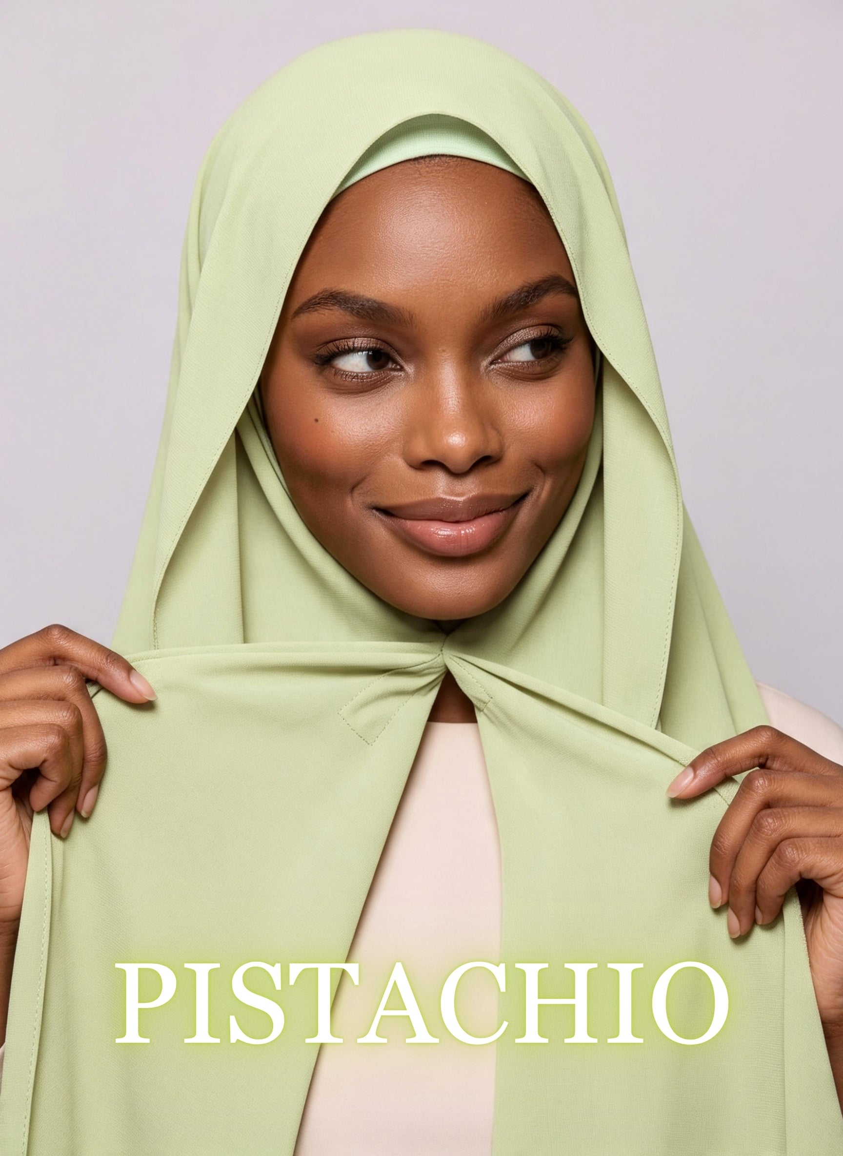 Woman wearing pistachio green NurAmira instant chiffon hijab with front panels held by magnets and smooth drape in white studio