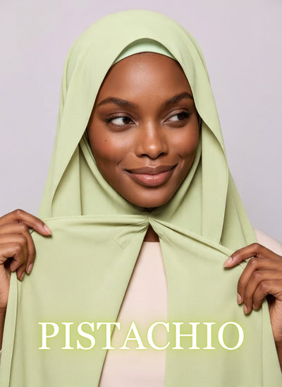 Woman wearing pistachio green NurAmira instant chiffon hijab with front panels held by magnets and smooth drape in white studio