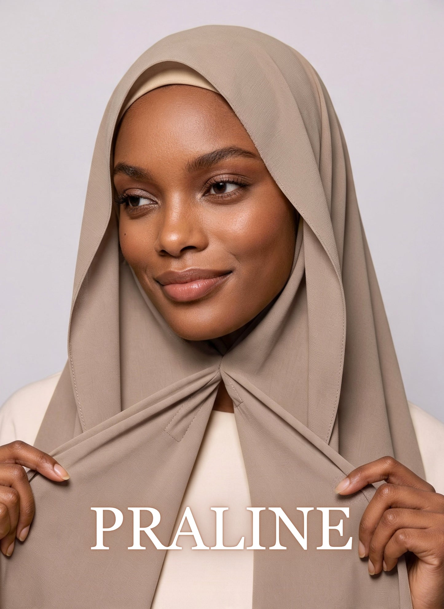 Woman wearing praline beige NurAmira instant chiffon hijab with front panels held by magnets and smooth drape in white studio