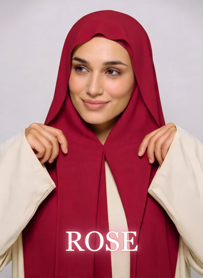 Woman wearing rose red NurAmira instant chiffon hijab with front panels held by magnets and smooth drape in white studio
