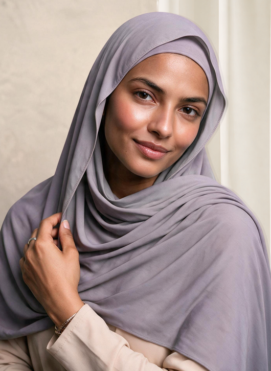 Woman wearing NurAmira Instant Chiffon Hijab in Duman lavender-gray shade, draped over shoulder style.