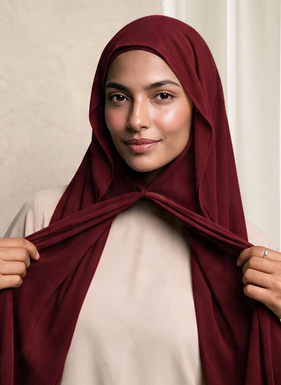 Woman wearing NurAmira Instant Chiffon Hijab in Garnet deep red shade, magnet closure style.