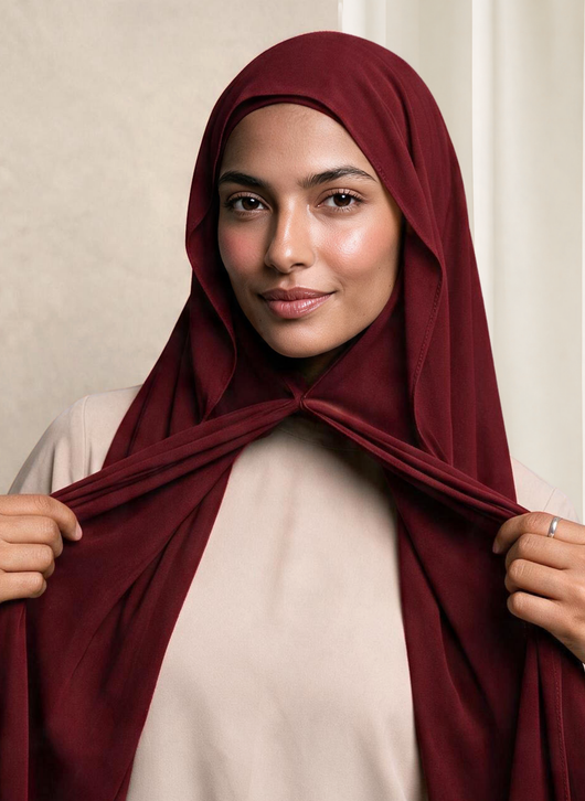Woman wearing NurAmira Instant Chiffon Hijab in Garnet deep red shade, magnet closure style.