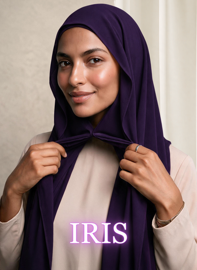 Woman wearing NurAmira Instant Chiffon Hijab in Iris deep purple shade, draped and knotted style.