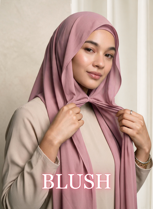 Woman wearing NurAmira™ Instant Chiffon Hijab in Blush, gently holding the front drape.