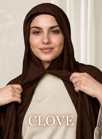Front-facing woman wearing the NurAmira™ Instant Chiffon Hijab in Clove, lightly holding the front drape.