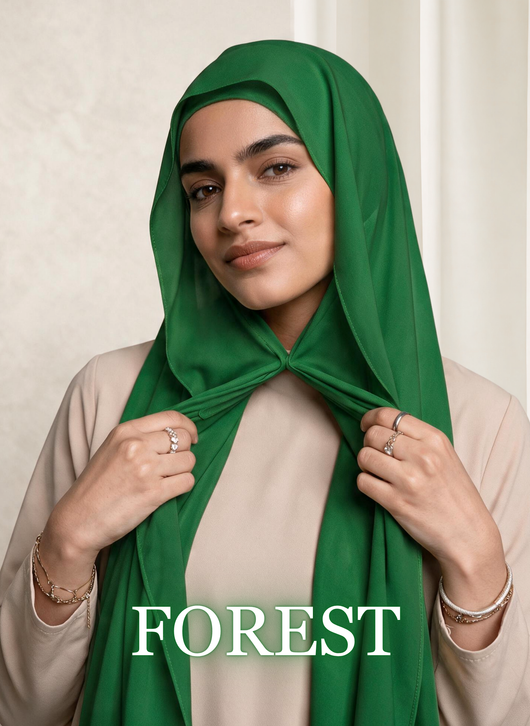 Woman wearing NurAmira™ Instant Chiffon Hijab in Forest, holding the front drape with both hands.