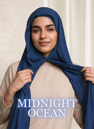 Woman wearing NurAmira™ Instant Chiffon Hijab in Midnight Ocean, holding one side of the chiffon drape.