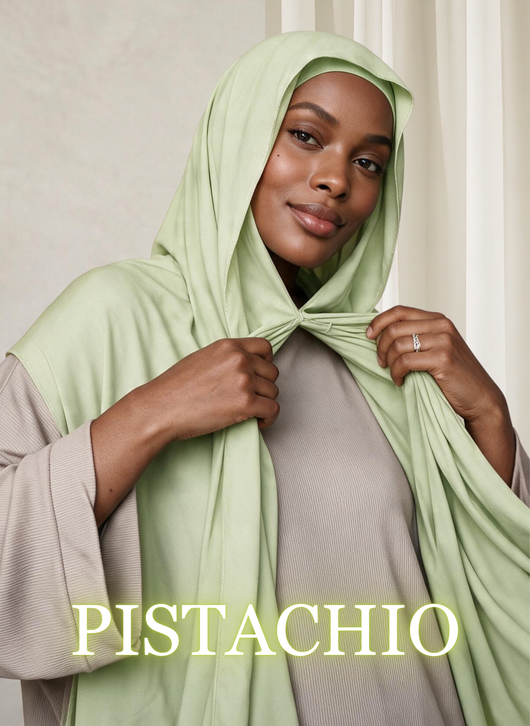 Woman wearing NurAmira™ Instant Chiffon Hijab in Pistachio, holding the front drape.