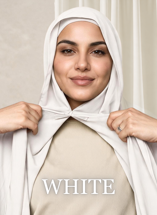 Woman wearing the NurAmira™ Instant Chiffon Hijab in White, holding both sides of the scarf to showcase the built-in undercap.