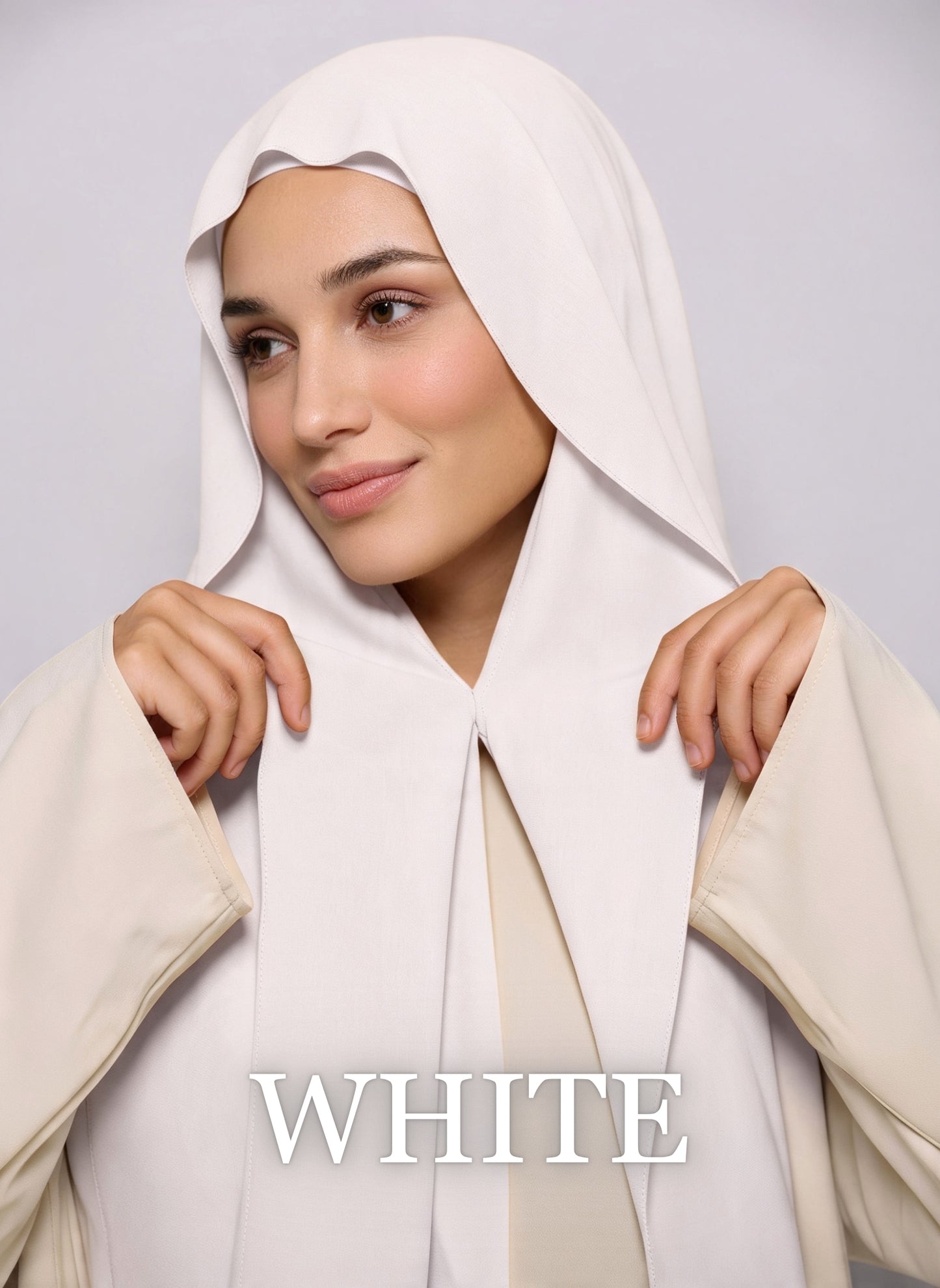 Woman wearing white NurAmira instant chiffon hijab with front panels held by magnets and smooth drape in white studio