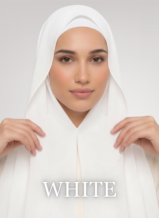 Woman wearing white NurAmira instant chiffon hijab with front panels held by magnets and smooth drape in white studio