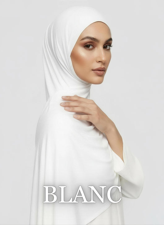 Woman wearing white Jersey hijab with smooth elegant drape in white studio
