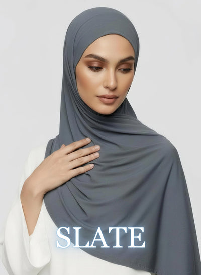 Woman wearing slate gray Jersey hijab with smooth drape in white studio