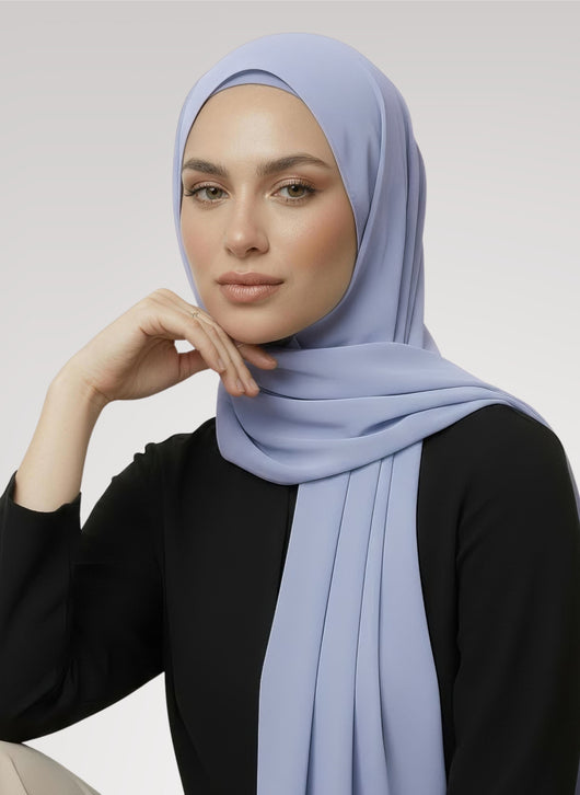 Woman wearing icy blue samaa Nuramira instant chiffon hijab attached to undercap with classic drape wrap in white studio