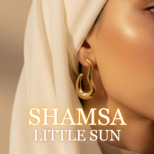 Woman wearing Shamsa gold hoop earrings with light hijab in sunlight