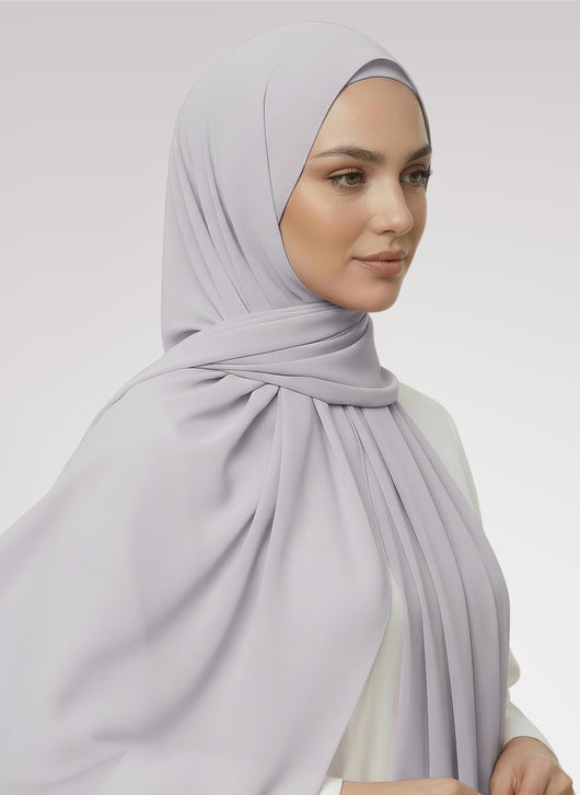 Woman wearing grayish prple Nuramira instant chiffon hijab attached to undercap with layered drape in white studio